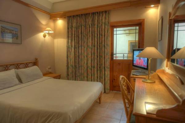 Zimmer im Saint Patrick's Hotel Gozo mit Bett, Schreibtisch, Stuhl und Fernseher.