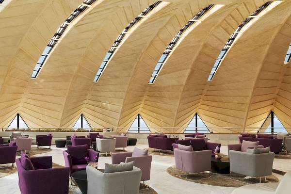Loungebereich im H10 Playa Meloneras Palace mit vielen weichen Möbeln und großen Fenstern.