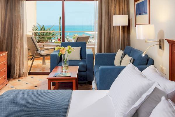 Hotelzimmer im H10 Playa Meloneras Palace mit Blick auf das Meer und eine Terrasse.