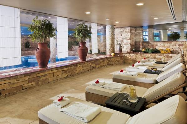 Lounge-Bereich im H10 Playa Meloneras Palace mit Blick auf den Pool, Lounge-Sesseln und Pflanzen.