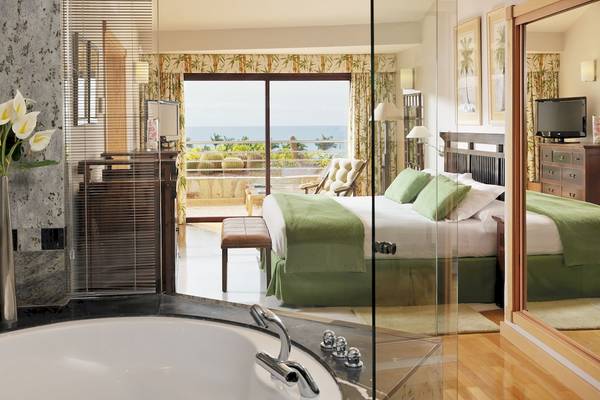 Schlafzimmer des H10 Playa Meloneras Palace Hotels mit großem Bett, Aussicht auf das Meer und Balkon.