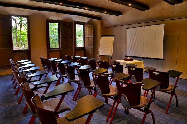 Konferenzraum im Odyssee Resort Thalasso & Spa mit roten Stühlen und einem Projektionsbild