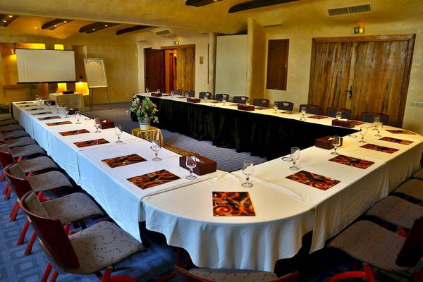 Konferenzraum im Odyssee Resort Thalasso & Spa mit U-förmigem Tisch, Stühlen und Blumenvase.