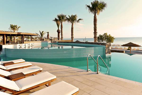 Pool des Blue Sea Beach Hotels mit Palmen und Meer im Hintergrund