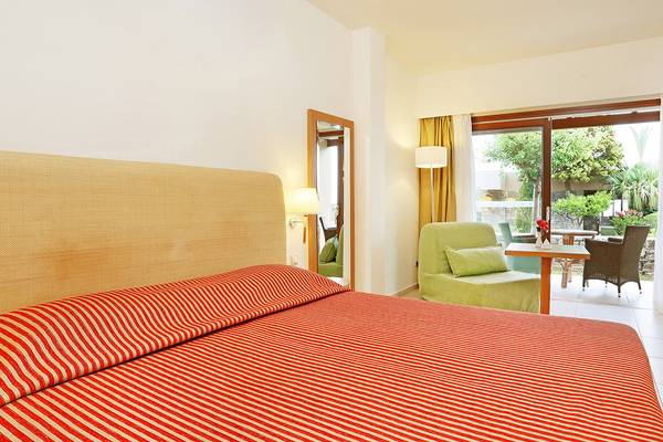Zimmer im Blue Sea Beach Affiliated by Melia mit rotem Bett und Zugang zur Terrasse