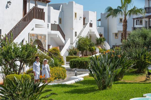 Paar im Freien vor dem Alexander Beach Hotel & Village Resort.