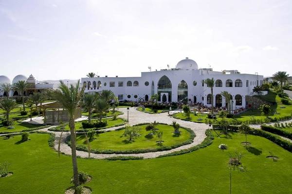 Luftaufnahme des Gorgonia Beach Resorts mit gepflegtem Garten und mehreren Palmen.