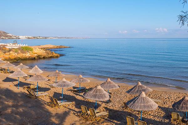 Alexander Beach Hotel Strand mit Sonnenschirmen und Liegen