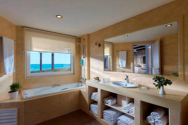 Badezimmer im Alexander Beach Hotel mit Blick auf das Meer und modernen Einrichtungen.