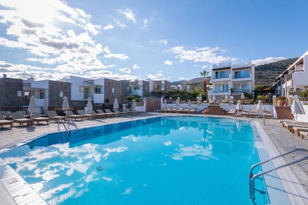 Außenpool des Alexander Beach Hotel & Village Resort mit Liegestühlen und Sonnenschirmen