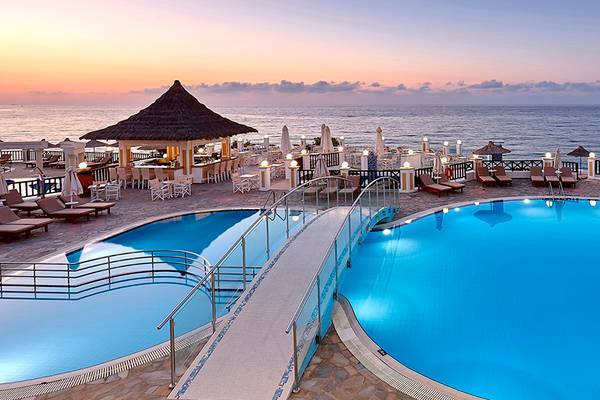 Außenpoolbereich des Alexander Beach Hotel mit Sonnenuntergang und Meerblick