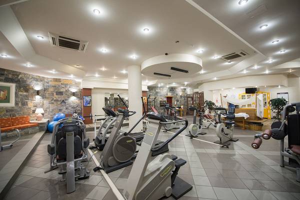 Fitnesscenter im Alexander Beach Hotel mit diversen Trainingsgeräten und gut beleuchtet
