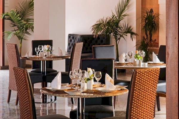 Restaurant des Pickalbatros Aqua Fun Club Hotels mit gedeckten Tischen und Pflanzen im Hintergrund.