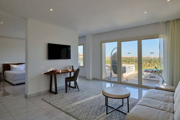 Ein modernes Zimmer im Steigenberger Pure Lifestyle Hotel mit einem Schreibtisch, einem Bett und einem großen Fenster.