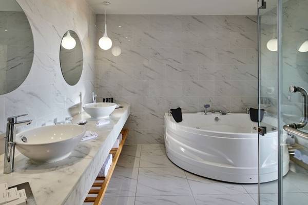 Badezimmer mit Badewanne und Doppel-Waschbecken im Steigenberger Pure Lifestyle Hotel