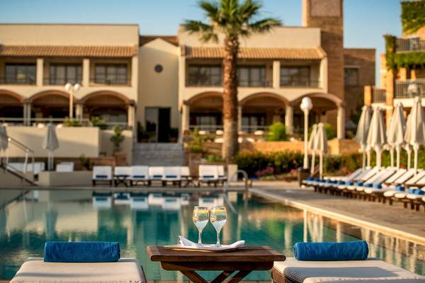 Der Poolbereich des Bella Beach Hotels mit Getränken und Sonnenliegen.