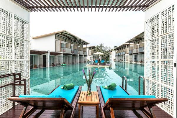 Ein Swimmingpool des Briza Beach Resorts mit zwei Liegen und einem Tisch.