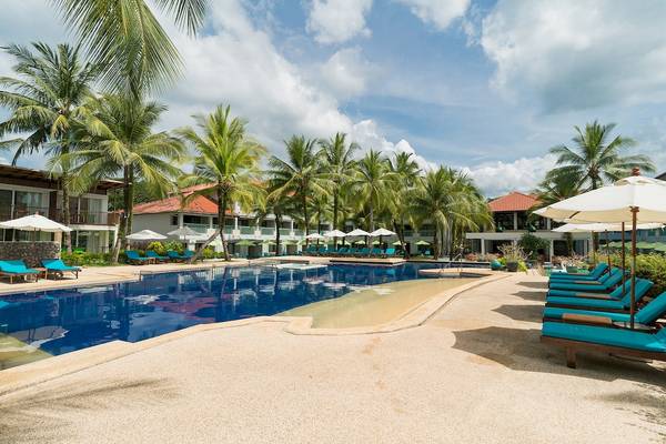 Poolbereich des Briza Beach Resorts mit Sonnenliegen und Palmen