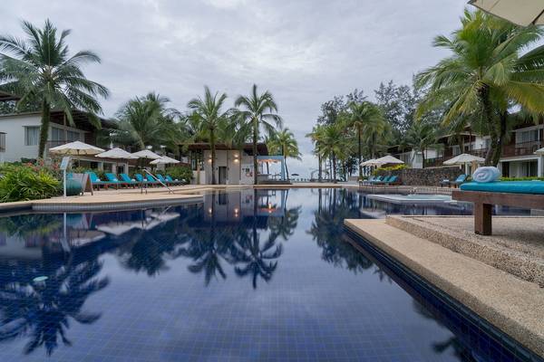 Poolbereich des Briza Beach Resorts mit blauen Liegen und Sonnenschirmen.