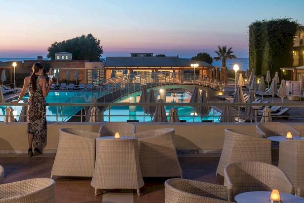 Ein Hotelgast steht auf der Terrasse des Bella Beach Hotels und genießt den Blick auf den Pool.