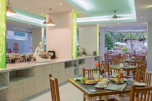 Blick auf den Frühstücksraum des Briza Beach Resorts mit Tisch, Stühlen und Frühstücksbuffet.
