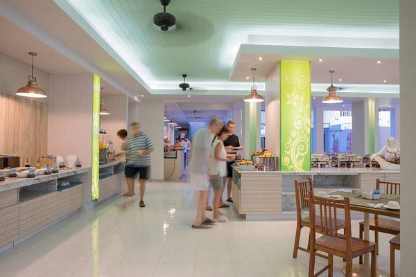 Das Innere des Restaurants im Briza Beach Resort mit Gästen, die an Buffets vorbeigehen.