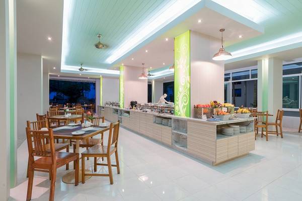 Briza Beach Resort Restaurant mit grünen Säulen und serviertem Essen.