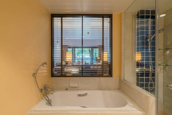 Badezimmer mit Badewanne und Fenster im Briza Beach Resort