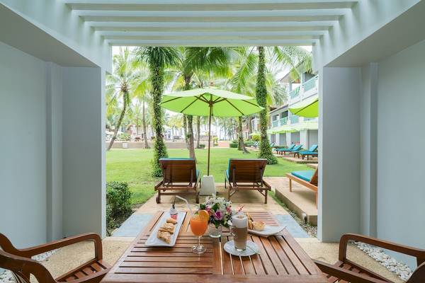 Terrasse im Briza Beach Resort mit Tisch, Getränken und Sonnenschirm im Freien
