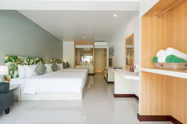Hotelzimmer im Briza Beach Resort mit weißen Möbeln, tropischen Kopfteilen und hellen Fliesen.