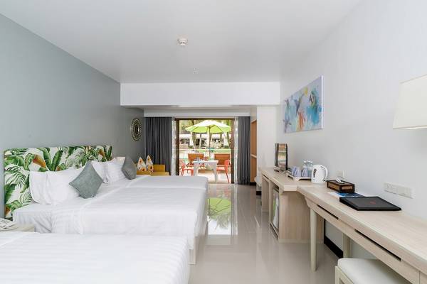 Doppelbettzimmer im Briza Beach Resort mit Blick auf den Garten und einem Schreibtisch.