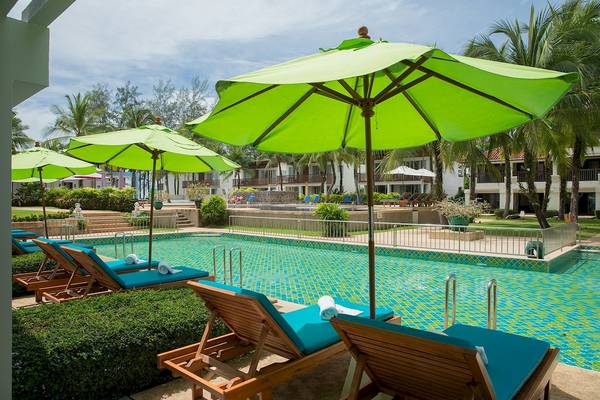 Pool mit blauen Liegestühlen und grünen Sonnenschirmen im Briza Beach Resort