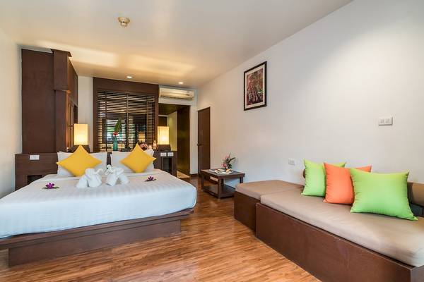 Hotelzimmer im Briza Beach Resort mit einem Bett, Sofa und Dekokissen.