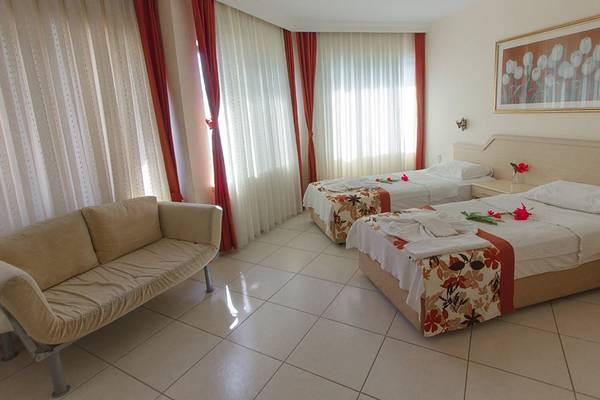 Hotelzimmer im Malhun Hotel mit zwei Betten, einem Sofa und weißem Teppichboden.