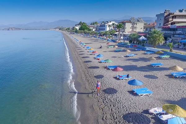 Luftaufnahme der Malhun Hotel Strand mit vielen Liegen und Sonnenschirmen am Meer.