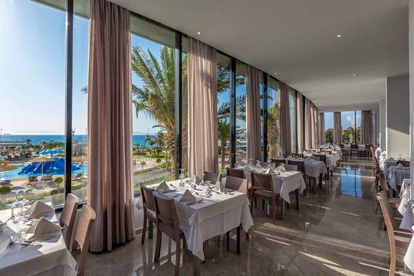Restaurant des Akti Imperial Deluxe Resorts mit Meerblick und großen Fenstern.