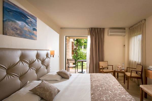 Bella Beach Hotel Zimmer mit zwei Betten und Balkonzugang.
