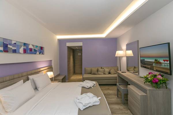 Hotelzimmer im Akti Imperial Deluxe Resort & Spa mit Bett, Couch und Fernseher.