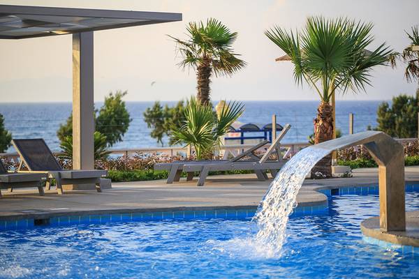 Ein Swimmingpool mit Liegen und Palmen im Akti Imperial Deluxe Resort.