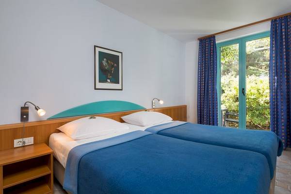 Doppelzimmer im Bretanide Sport & Wellness Resort mit zwei Betten, Fenstern und einer malerischen Aussicht.