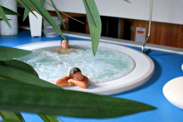 Gäste entspannen im Whirlpool des Bretanide Sport & Wellness Resorts