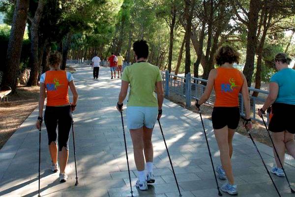 Gruppe von Frauen beim Nordic Walking im Wald am Bretanide Sport & Wellness Resort.