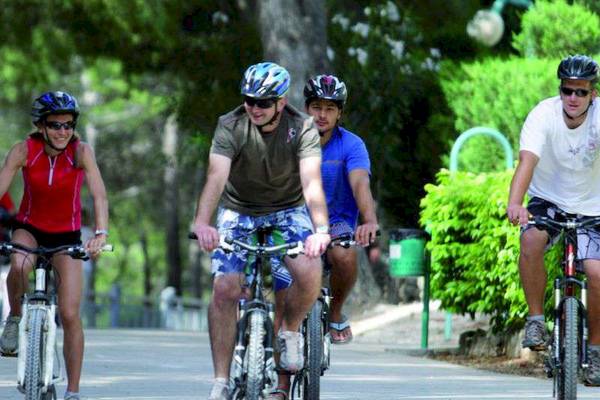 Vier Personen radeln auf einem Pfad im Bretanide Sport & Wellness Resort.
