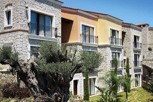 Außenansicht des Cocos The Club Solto Hotels mit mehreren Steingebäuden und Balkonen.