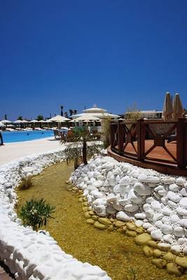 Poolbereich des Cocos The Club Solto Hotels mit weißen Steinen und Wassergraben.
