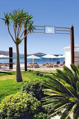 Außenbereich des Cocos The Club Solto Hotels mit Blick auf den Strand und weißen Sonnenschirmen.