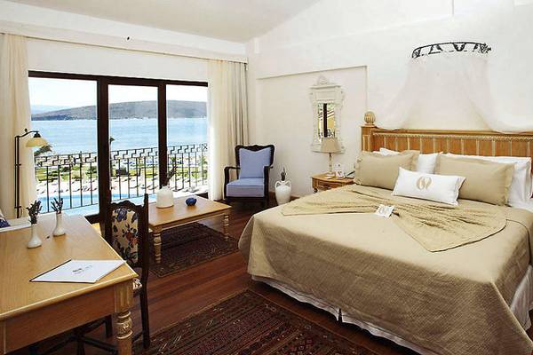 Hotelzimmer von Cocos The Club Solto mit Blick auf den Ozean, ausgestattet mit einem großen Bett, Schreibtisch und Balkon.