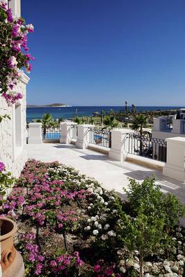 Terrasse im Cocos The Club Solto mit Blick auf das Meer und Blumenbeete.