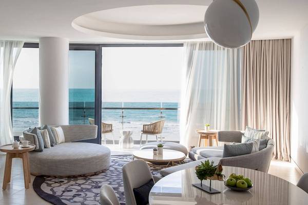 Wohnbereich des Jumeirah at Saadiyat Island Resort mit Meerblick, inklusive Sofa, Tisch und Balkon.