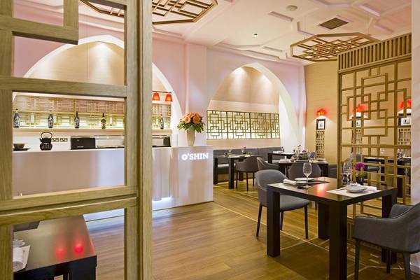 Innenansicht des O'Shin Restaurants im Elysium Hotel mit Holzböden und modernen Möbeln.